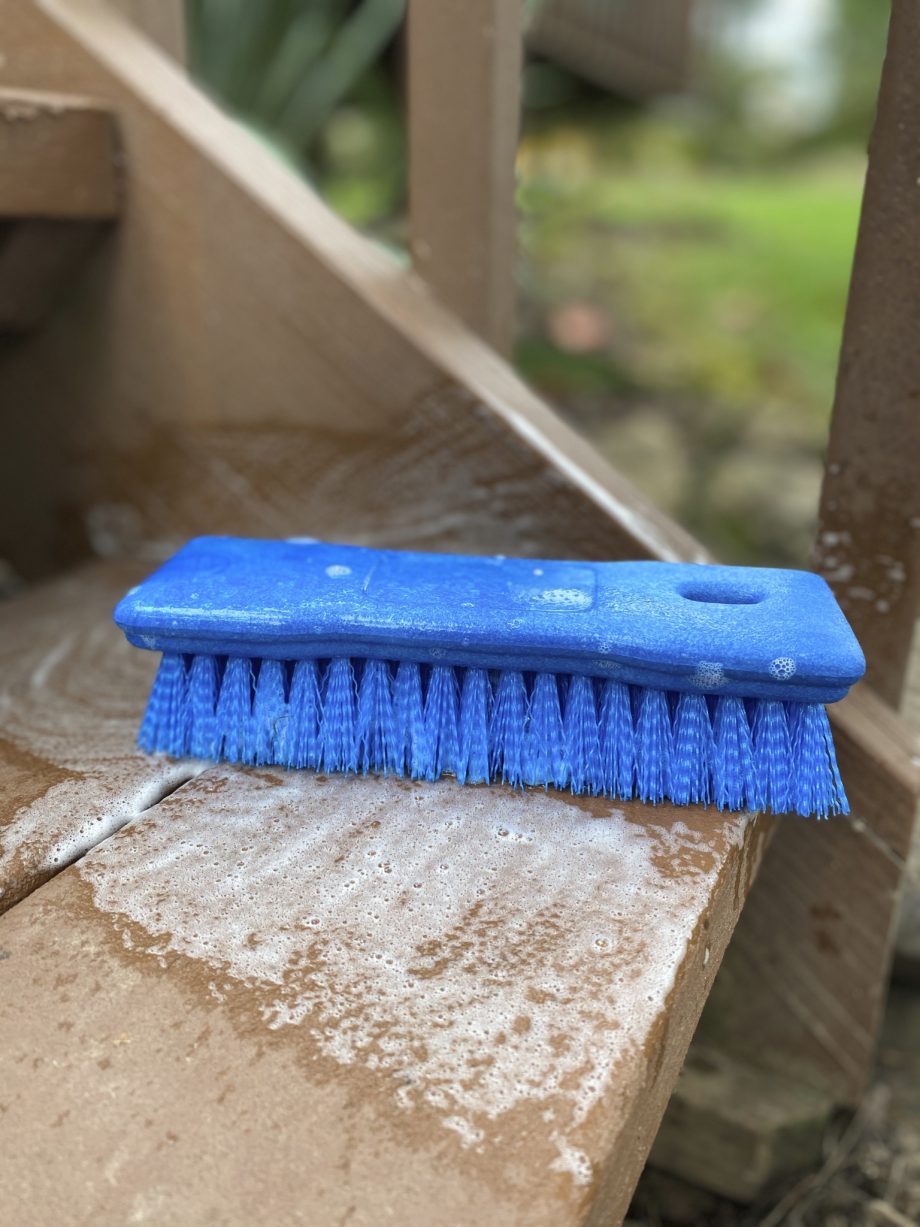 Comfort Grip Scrub Brush blue on step of porch