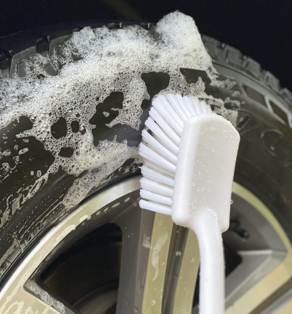 Long Handled Scrub Brush scrubbing tire on car