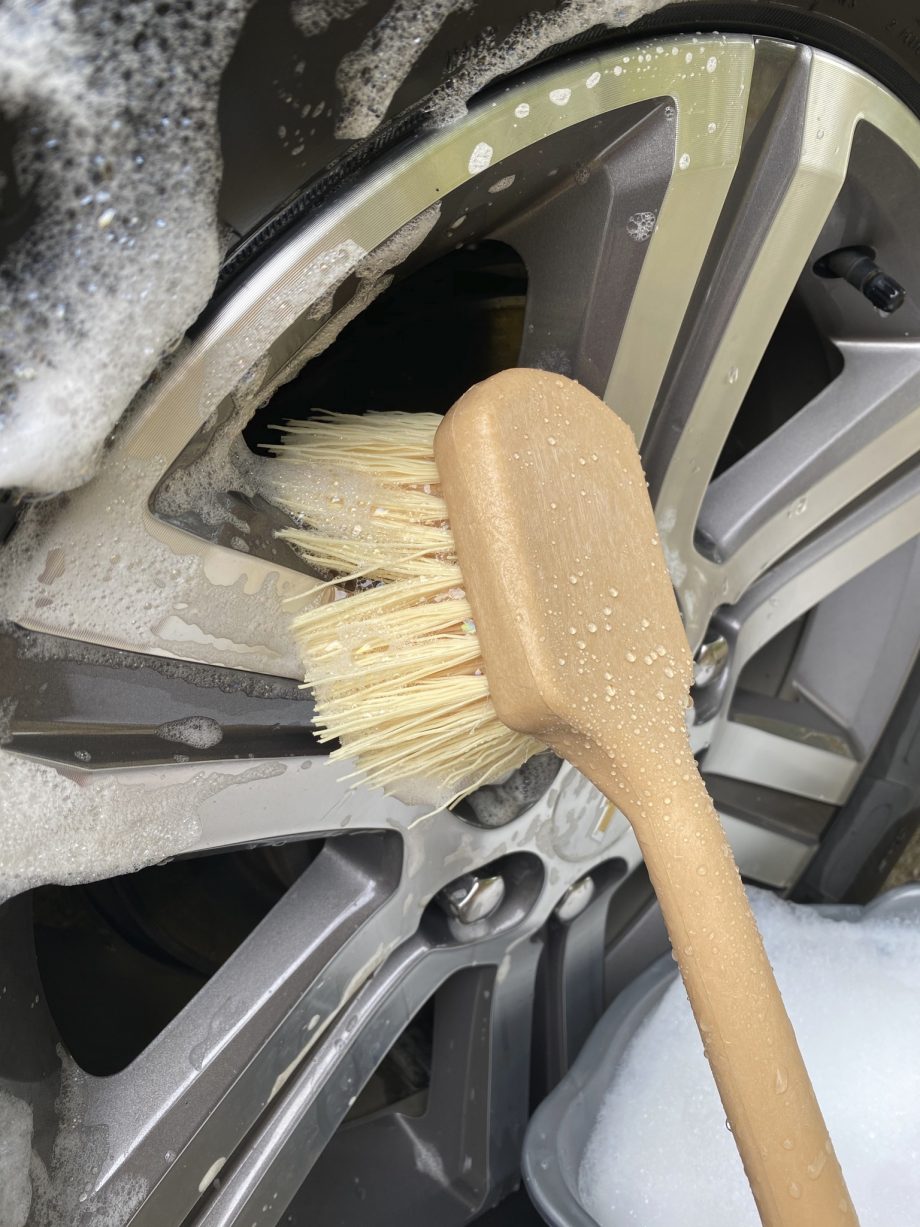 vehicle brush scrubbing wheels on a car