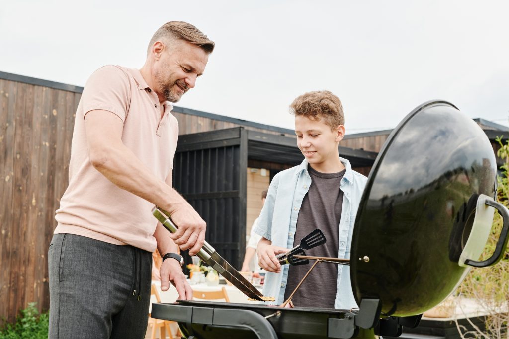 Grill with lid and a father and son grilling